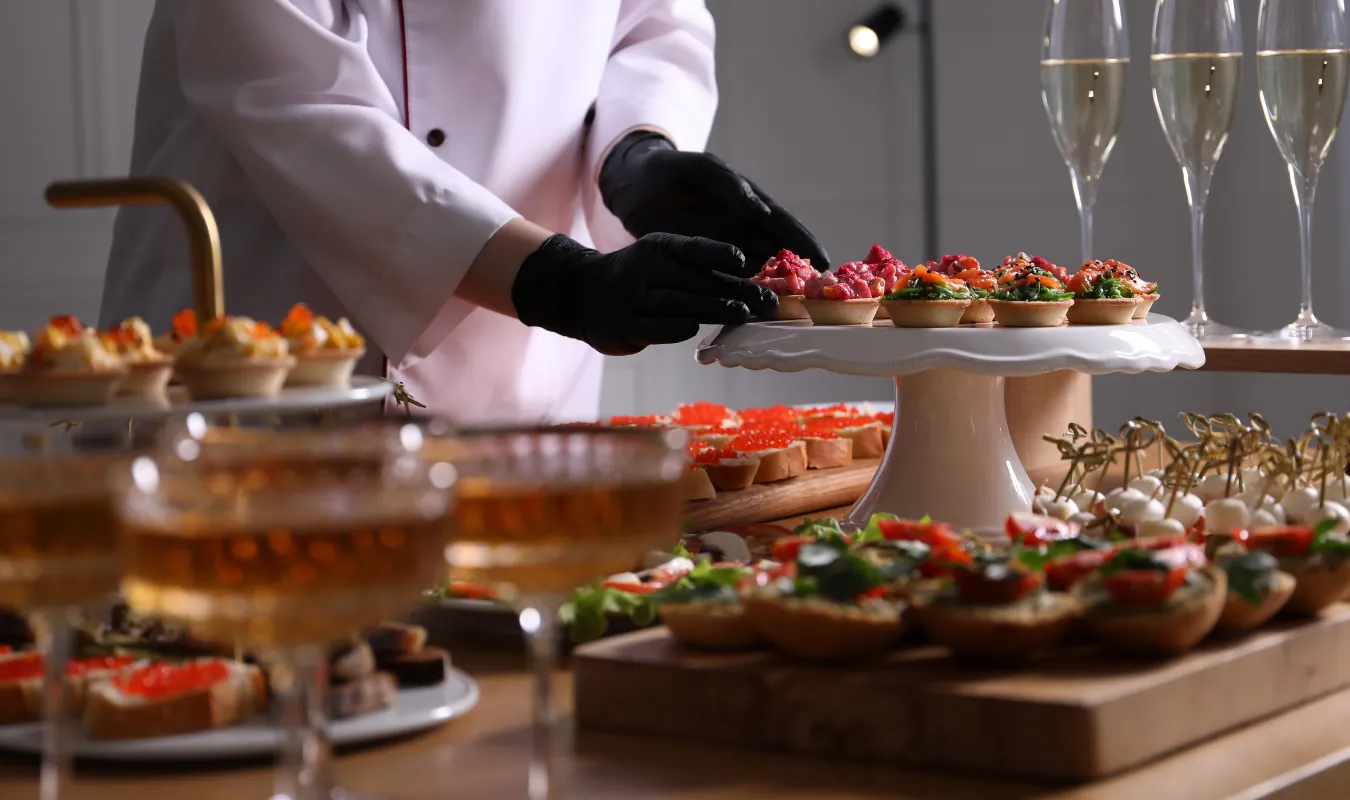 Claire plating canapés at a private event