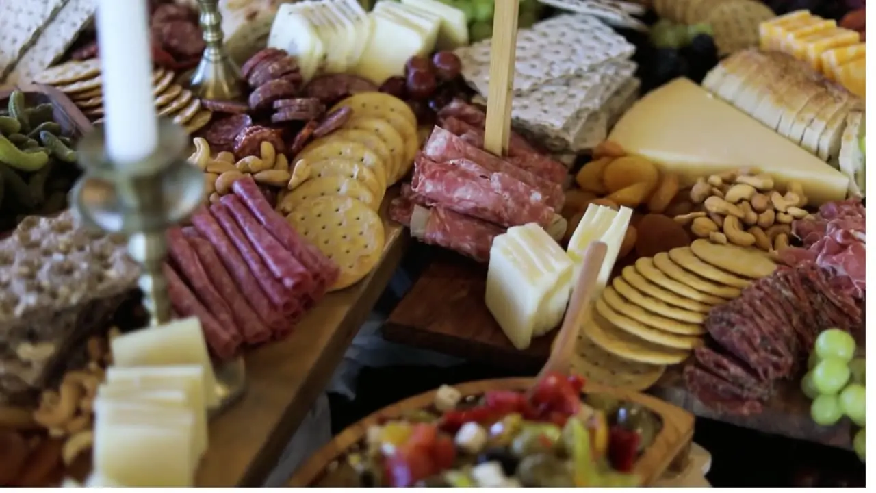 A grazing board of cured meats, cheeses, nuts and crackers laid out for an event